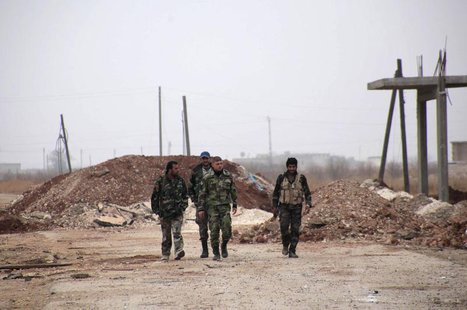 Forces loyal to Syria's President Bashar al-Assad carry their weapons as they walk along a road in the town of Tel Arn in Aleppo after captu Forces loyal to Syria's President Bashar al-Assad carry their weapons as they walk along a road in the town of Tel Arn in Aleppo after captu