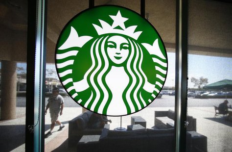A Starbucks logo hangs on a window at a newly designed Starbucks coffee shop in Fountain Valley, California August 22, 2013. REUTERS/Mike Bl A Starbucks logo hangs on a window at a newly designed Starbucks coffee shop in Fountain Valley, California August 22, 2013. REUTERS/Mike Bl