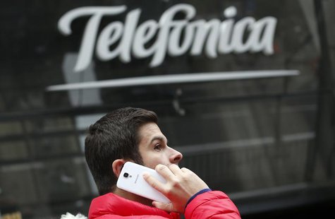A man talks on a mobile phone as he walks past Spanish telecom group Telefonica's flagship store in central Madrid November 8, 2013. REUTERS A man talks on a mobile phone as he walks past Spanish telecom group Telefonica's flagship store in central Madrid November 8, 2013. REUTERS