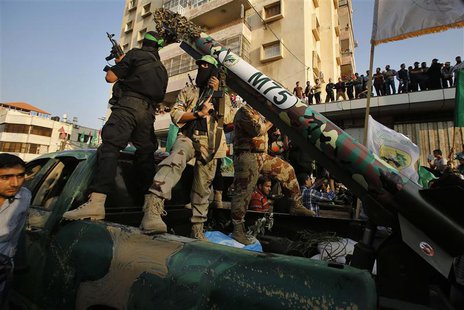 Palestinian Hamas militants stand next to M-75 home made rocket as they take part in a military parade marking the first anniversary of the Palestinian Hamas militants stand next to M-75 home made rocket as they take part in a military parade marking the first anniversary of the