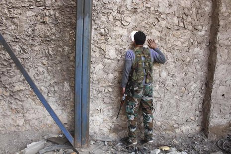 A Fighter from Tawhid Brigade, which operates under the Free Syrian Army, looks through a hole in the wall in Base 80 area of Aleppo, Novemb A Fighter from Tawhid Brigade, which operates under the Free Syrian Army, looks through a hole in the wall in Base 80 area of Aleppo, Novemb