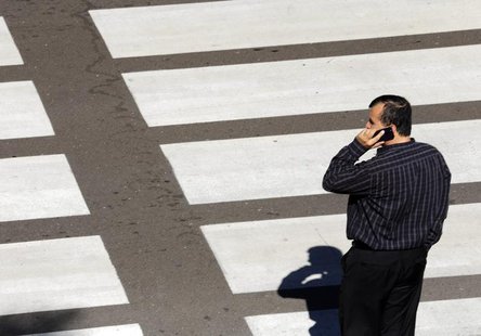 A man talks on his mobile phone as he waits at a crosswalk at Lindbergh Field Airport in San Diego, California, November 6, 2013. REUTERS/Mi A man talks on his mobile phone as he waits at a crosswalk at Lindbergh Field Airport in San Diego, California, November 6, 2013. REUTERS/Mi