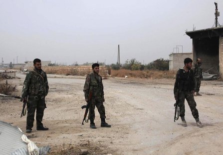 Forces loyal to Syria's President Bashar al-Assad carry their weapons as they stand along a road in the town of Tel Arn in Aleppo after capt Forces loyal to Syria's President Bashar al-Assad carry their weapons as they stand along a road in the town of Tel Arn in Aleppo after capt