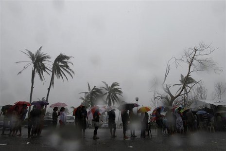 Survivors queue during a downpour to charge their mobile phones at a government-provided power generator in the aftermath of super typhoon H Survivors queue during a downpour to charge their mobile phones at a government-provided power generator in the aftermath of super typhoon H