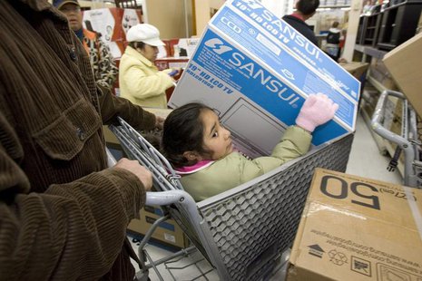 A girl sits in a shopping cart as she holds a television in a Walmart store in Oakland, California, November 28, 2008. REUTERS/Kimberly Whit A girl sits in a shopping cart as she holds a television in a Walmart store in Oakland, California, November 28, 2008. REUTERS/Kimberly Whit