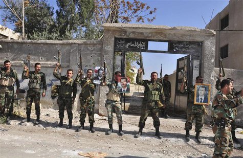 Soldiers loyal to Syria's President Bashar al-Assad raise their weapons while carrying pictures of him at Sbeineh town, southern Damascus, a Soldiers loyal to Syria's President Bashar al-Assad raise their weapons while carrying pictures of him at Sbeineh town, southern Damascus, a