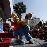 The characters of Homer (R) and Bart Simpson pose by the star of Matt Groening, creator of "The Simpsons," before it was unveiled on the Wal The characters of Homer (R) and Bart Simpson pose by the star of Matt Groening, creator of "The Simpsons," before it was unveiled on the Wal