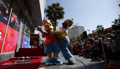 The characters of Homer (R) and Bart Simpson pose by the star of Matt Groening, creator of "The Simpsons," before it was unveiled on the Wal The characters of Homer (R) and Bart Simpson pose by the star of Matt Groening, creator of "The Simpsons," before it was unveiled on the Wal