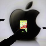 Men are silhouetted against a video screen with an Apple Inc logo as they pose with a Samsung Galaxy S3 smartphone in this photo illustratio Men are silhouetted against a video screen with an Apple Inc logo as they pose with a Samsung Galaxy S3 smartphone in this photo illustratio