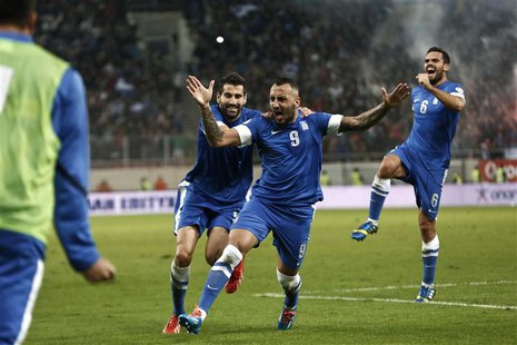 Greece's Kostas Mitroglou (C), Dimitris Siovas (L) and Alexandros Tziolis celebrate a goal against Romania during their 2014 World Cup quali Greece's Kostas Mitroglou (C), Dimitris Siovas (L) and Alexandros Tziolis celebrate a goal against Romania during their 2014 World Cup quali