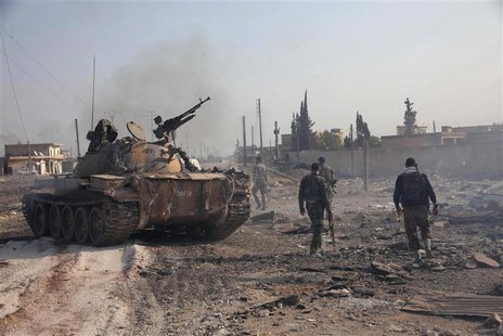 Forces loyal to Syria's President Bashar al-Assad hold their weapon as they stand near a tank in Tel Hasel, Aleppo province after capturing Forces loyal to Syria's President Bashar al-Assad hold their weapon as they stand near a tank in Tel Hasel, Aleppo province after capturing