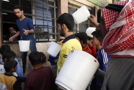 Residents carry buckets as wait for their turn to receive free meals from a soup kitchen in the city of Raqqa, eastern Syria October 7, 2013 Residents carry buckets as wait for their turn to receive free meals from a soup kitchen in the city of Raqqa, eastern Syria October 7, 2013