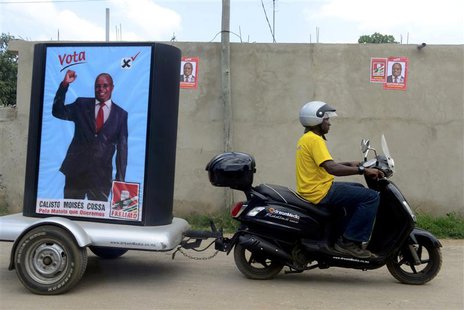 A supporter of the ruling Frelimo party rides a motorcycle with an election poster in tow in the capital Maputo November 16, 2013. Mozambiqu A supporter of the ruling Frelimo party rides a motorcycle with an election poster in tow in the capital Maputo November 16, 2013. Mozambiqu
