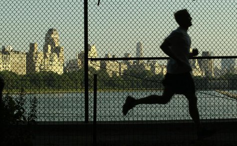 A man jogs along a path around the Central Park Reservoir with the buildings of Fifth Avenue in the backround in New York's famed Central Pa A man jogs along a path around the Central Park Reservoir with the buildings of Fifth Avenue in the backround in New York's famed Central Pa