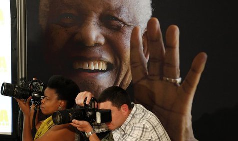 Photographers take pictures in front of a poster of anti-apartheid leader and former president Nelson Mandela during a news conference with Photographers take pictures in front of a poster of anti-apartheid leader and former president Nelson Mandela during a news conference with