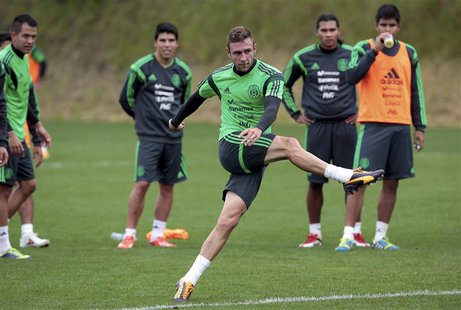 Mexico's Miguel Layun is watched by his team mates as he kicks a ball at a training session for their 2014 World Cup qualifying playoff seco Mexico's Miguel Layun is watched by his team mates as he kicks a ball at a training session for their 2014 World Cup qualifying playoff seco