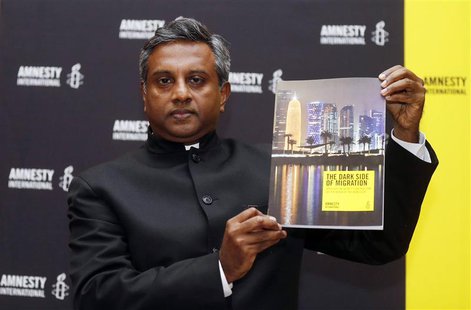 Amnesty International Secretary General Salil Shetty holds up a report titled "The Dark Side of Migration: Spotlight on Qatar’s construction Amnesty International Secretary General Salil Shetty holds up a report titled "The Dark Side of Migration: Spotlight on Qatar’s construction
