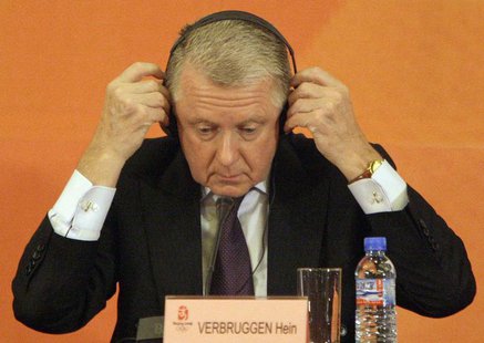 Hein Verbruggen, Chairman of the International Olympic Committee (IOC) Coordination Commission, puts on his headphones during a news confere Hein Verbruggen, Chairman of the International Olympic Committee (IOC) Coordination Commission, puts on his headphones during a news confere