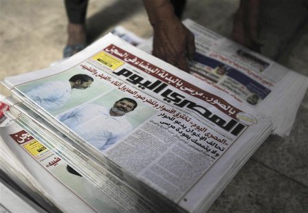A shopkeeper sells copies of the daily newspaper Al-Masry Al-Youm with pictures of ousted Egyptian President Mohamed Mursi in white prison u A shopkeeper sells copies of the daily newspaper Al-Masry Al-Youm with pictures of ousted Egyptian President Mohamed Mursi in white prison u