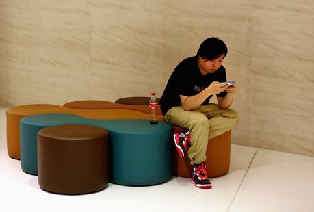 A man looks at his smart phone inside a shopping mall in downtown Shanghai, September 25, 2013. REUTERS/Carlos Barria A man looks at his smart phone inside a shopping mall in downtown Shanghai, September 25, 2013. REUTERS/Carlos Barria