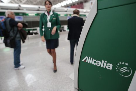 An Alitalia worker walks near an Alitalia auto check-in machine at Fiumicino airport in Rome October 11, 2013. REUTERS/Tony Gentile An Alitalia worker walks near an Alitalia auto check-in machine at Fiumicino airport in Rome October 11, 2013. REUTERS/Tony Gentile