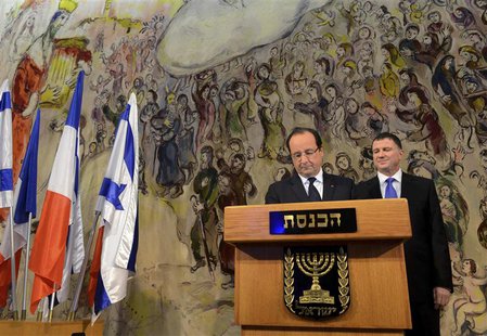 Yuli Edelstein (R), Speaker of the Knesset, Israel's parliament, stands behind France's President Francois Hollande as he signs the guest bo Yuli Edelstein (R), Speaker of the Knesset, Israel's parliament, stands behind France's President Francois Hollande as he signs the guest bo