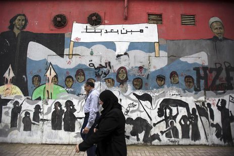 People walk in front of a mural depicting victims of the Egyptian uprising at Mohamed Mahmoud street near Tahrir Square in Cairo, November 1 People walk in front of a mural depicting victims of the Egyptian uprising at Mohamed Mahmoud street near Tahrir Square in Cairo, November 1