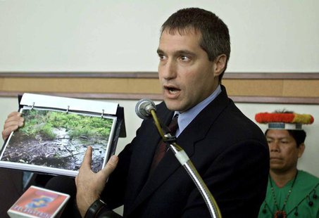 Attorney Steven Donziger shows pictures of a pool of oil which has seeped out from an oil waste pit left behind by Texaco at an oil pump sit Attorney Steven Donziger shows pictures of a pool of oil which has seeped out from an oil waste pit left behind by Texaco at an oil pump sit