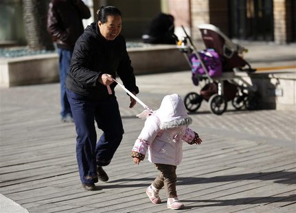 A woman holds onto a safety string attached to the back of a child at a shopping mall in Beijing, November 18, 2013. REUTERS/Kim Kyung-Hoon A woman holds onto a safety string attached to the back of a child at a shopping mall in Beijing, November 18, 2013. REUTERS/Kim Kyung-Hoon