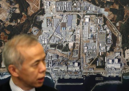 Tokyo Electric Power Co's (TEPCO) President Naomi Hirose speaks to the media in front of a photo showing the tsunami-crippled TEPCO's Fukush Tokyo Electric Power Co's (TEPCO) President Naomi Hirose speaks to the media in front of a photo showing the tsunami-crippled TEPCO's Fukush