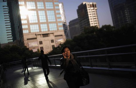 A woman talks on the phone as she walks along an elevated walkway in downtown Shanghai, November 18, 2013. REUTERS/Carlos Barria A woman talks on the phone as she walks along an elevated walkway in downtown Shanghai, November 18, 2013. REUTERS/Carlos Barria