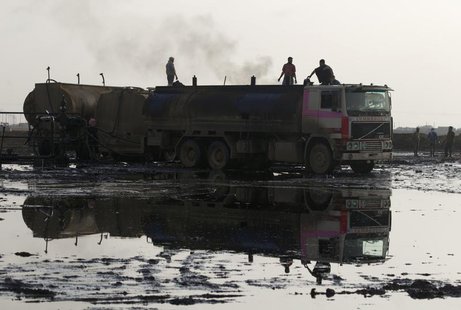 People stand on trucks near oil fields in Al-Rmelan, Qamshli province November 11, 2013. REUTERS/Stringer People stand on trucks near oil fields in Al-Rmelan, Qamshli province November 11, 2013. REUTERS/Stringer