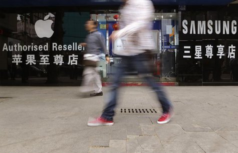 People walk past a mobile phone store selling Apple and Samsung products in Wuhan, Hubei province April 18, 2013. REUTERS/Stringer People walk past a mobile phone store selling Apple and Samsung products in Wuhan, Hubei province April 18, 2013. REUTERS/Stringer