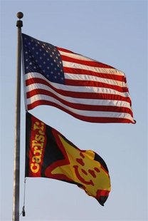 A Carl's Jr. fast food restaurant flag flies with a U.S. flag in Los Angeles, California May 11, 2012. REUTERS/David McNew A Carl's Jr. fast food restaurant flag flies with a U.S. flag in Los Angeles, California May 11, 2012. REUTERS/David McNew