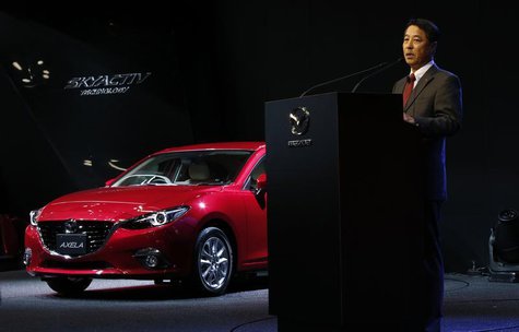 Mazda Motor Corp Chief Executive Officer Masamichi Kogai speaks next to the company's Axela (Mazda 3) compact car during a presentation at t Mazda Motor Corp Chief Executive Officer Masamichi Kogai speaks next to the company's Axela (Mazda 3) compact car during a presentation at t