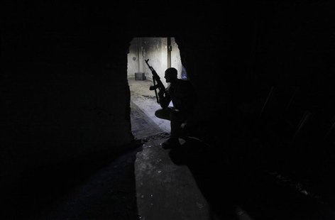 A Free Syrian Army fighter carries his weapon as he takes a position inside a room in Deir al-Zor, eastern Syria November 19, 2013. REUTERS/ A Free Syrian Army fighter carries his weapon as he takes a position inside a room in Deir al-Zor, eastern Syria November 19, 2013. REUTERS/