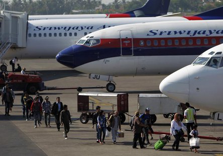 Passengers walk to their plane on the tarmac of Soekarno-Hatta airport in Jakarta, April 29, 2013. REUTERS/Beawiharta Passengers walk to their plane on the tarmac of Soekarno-Hatta airport in Jakarta, April 29, 2013. REUTERS/Beawiharta