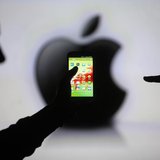 Men are silhouetted against a video screen with an Apple Inc logo as they pose with a Samsung Galaxy S3 smartphone in this photo illustratio Men are silhouetted against a video screen with an Apple Inc logo as they pose with a Samsung Galaxy S3 smartphone in this photo illustratio