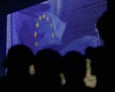 People are silhouetted against a screen showing the European Union flag as they attend a rally in support of euro integration in central Kie People are silhouetted against a screen showing the European Union flag as they attend a rally in support of euro integration in central Kie