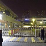 Police and security guards stand outside a gate of a Nokia factory during a protest of around one hundred factory workers in Dongguan, Guang Police and security guards stand outside a gate of a Nokia factory during a protest of around one hundred factory workers in Dongguan, Guang
