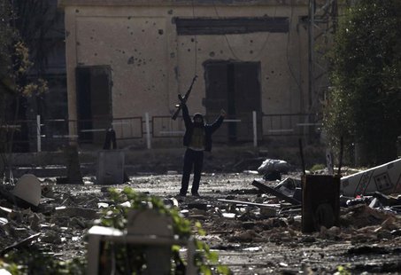 A Free Syrian Army fighter, standing on rubble, gestures as he holds up his weapon in Deir al-Zor, eastern Syria November 21, 2013. REUTERS/ A Free Syrian Army fighter, standing on rubble, gestures as he holds up his weapon in Deir al-Zor, eastern Syria November 21, 2013. REUTERS/