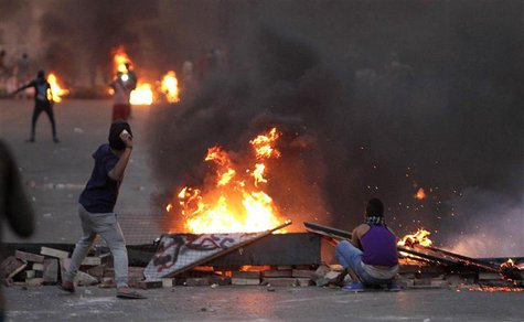 Supporters and opponents of ousted president Mohamed Mursi throw stones near burning tyres during clashes at Nasr City district, Cairo, Nove Supporters and opponents of ousted president Mohamed Mursi throw stones near burning tyres during clashes at Nasr City district, Cairo, Nove