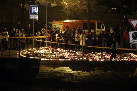 People gather near lit candles in front of a collapsed supermarket in capital Riga November 23, 2013. REUTERS/Ints Kalnins People gather near lit candles in front of a collapsed supermarket in capital Riga November 23, 2013. REUTERS/Ints Kalnins