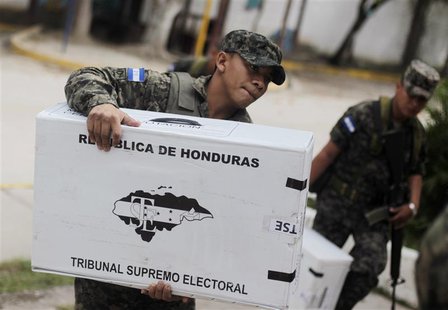 Soldiers carry ballot boxes into a school to be converted into a polling station in Tegucigalpa November 23, 2013. REUTERS/Jorge Cabrera Soldiers carry ballot boxes into a school to be converted into a polling station in Tegucigalpa November 23, 2013. REUTERS/Jorge Cabrera