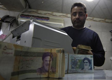 A man counts stacks of Iranian rials at a currency exchange shop in Kerbala , 110 km (70 miles) south of Baghdad January 23, 2013. REUTERS/M A man counts stacks of Iranian rials at a currency exchange shop in Kerbala , 110 km (70 miles) south of Baghdad January 23, 2013. REUTERS/M