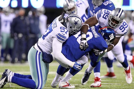 Nov 24, 2013; East Rutherford, NJ, USA; New York Giants quarterback Eli Manning (10) is sacked by Dallas Cowboys defensive tackle Jason Hatc Nov 24, 2013; East Rutherford, NJ, USA; New York Giants quarterback Eli Manning (10) is sacked by Dallas Cowboys defensive tackle Jason Hatc