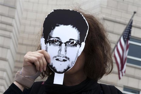 A woman holds a portrait of former U.S. spy agency contractor Edward Snowden in front of her face as she stands in front of the U.S. embassy A woman holds a portrait of former U.S. spy agency contractor Edward Snowden in front of her face as she stands in front of the U.S. embassy
