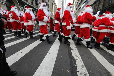Santas cross the street while marching through Midtown Manhattan during the Volunteers of America's 110th Annual Sidewalk Santa Parade in Ne Santas cross the street while marching through Midtown Manhattan during the Volunteers of America's 110th Annual Sidewalk Santa Parade in Ne