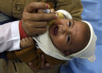 A health worker administers a polio vaccination to a child in Damascus November 20, 2013. REUTERS/Khaled al-Hariri A health worker administers a polio vaccination to a child in Damascus November 20, 2013. REUTERS/Khaled al-Hariri