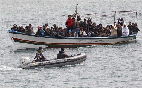 Migrants from North Africa arrive, escorted by Italian Guardia di Finanza, at the southern Italian island of Lampedusa in this March 14, 201 Migrants from North Africa arrive, escorted by Italian Guardia di Finanza, at the southern Italian island of Lampedusa in this March 14, 201
